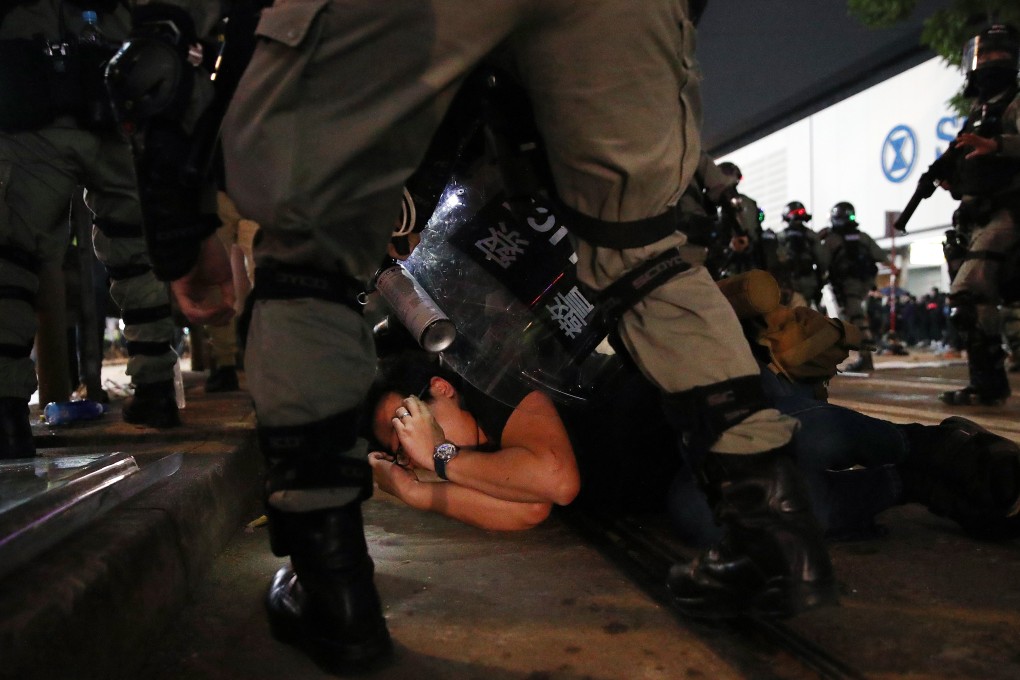 A police officer stands over an anti-government protester during a rally on New Year's Day. Photo: Winson Wong