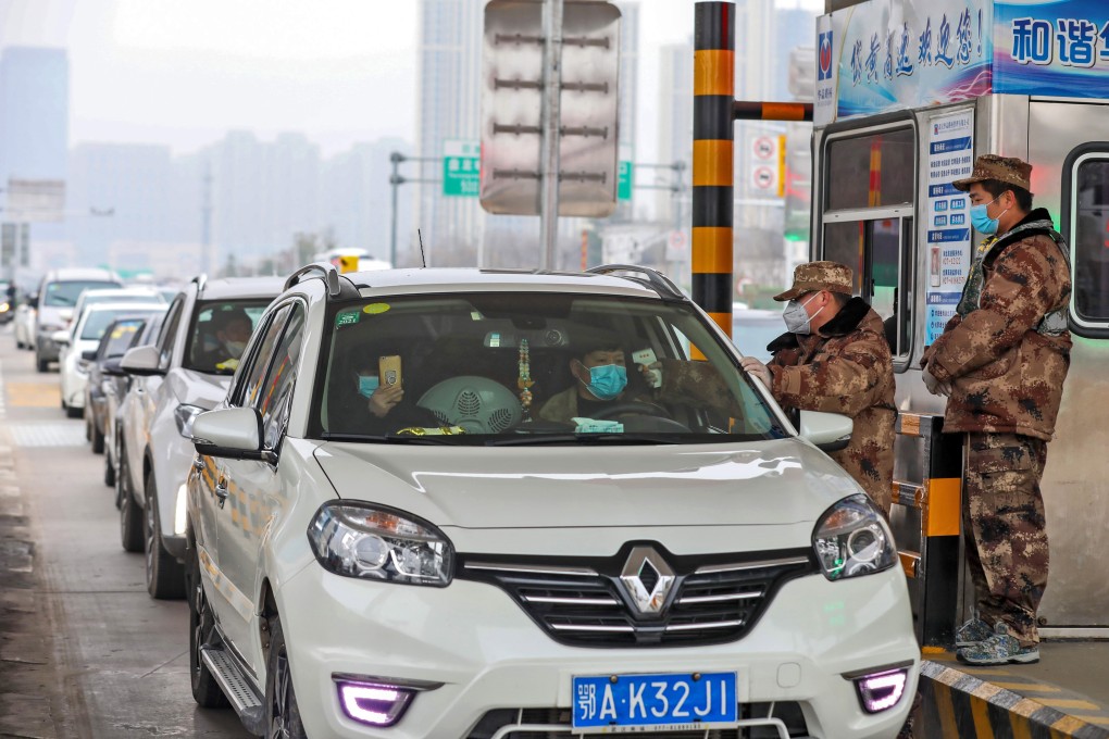 Paramilitary officers check the temperature of car passengers at a toll gate in Wuhan, in central China’s Hubei province on January 23. Photo: EPA-EFE