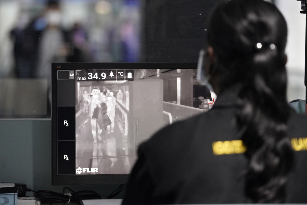 A health official watches travellers on a thermographic monitor to detect symptoms of the Wuhan virus at the Kuala Lumpur International Airport in Sepang, Malaysia, on January 25. Photo: AP