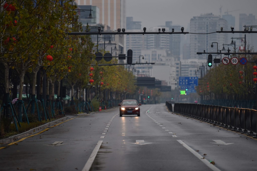 A lone car drives down an empty street in Wuhan, which has gone on lockdown to prevent the spread of the China coronavirus. Photo: AFP