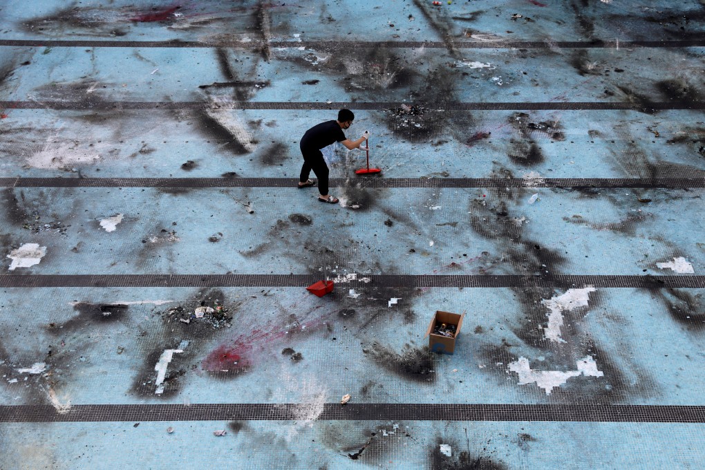 An anti-government protester cleans up after protests at Polytechnic University in Hong Kong on November 16, 2019. Photo: Reuters