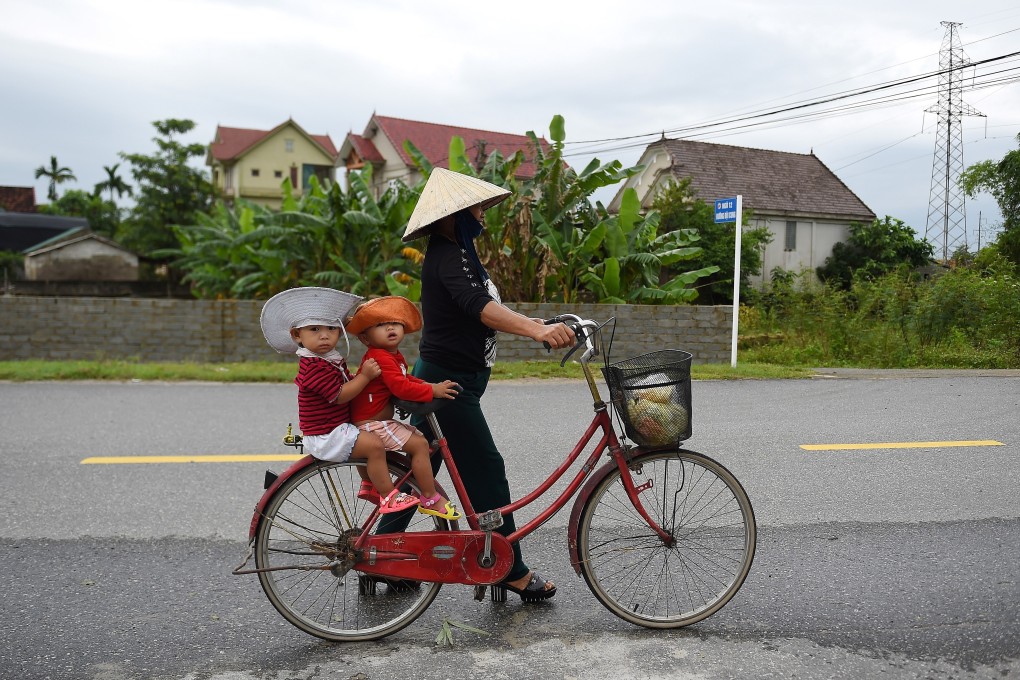 A Vietnamese woman carries children on a bicycle. Vietnam is one of the most region’s promising e-commerce markets, driven by its young population, growing middle class, high internet penetration and rising smartphone penetration. Photo: AFP