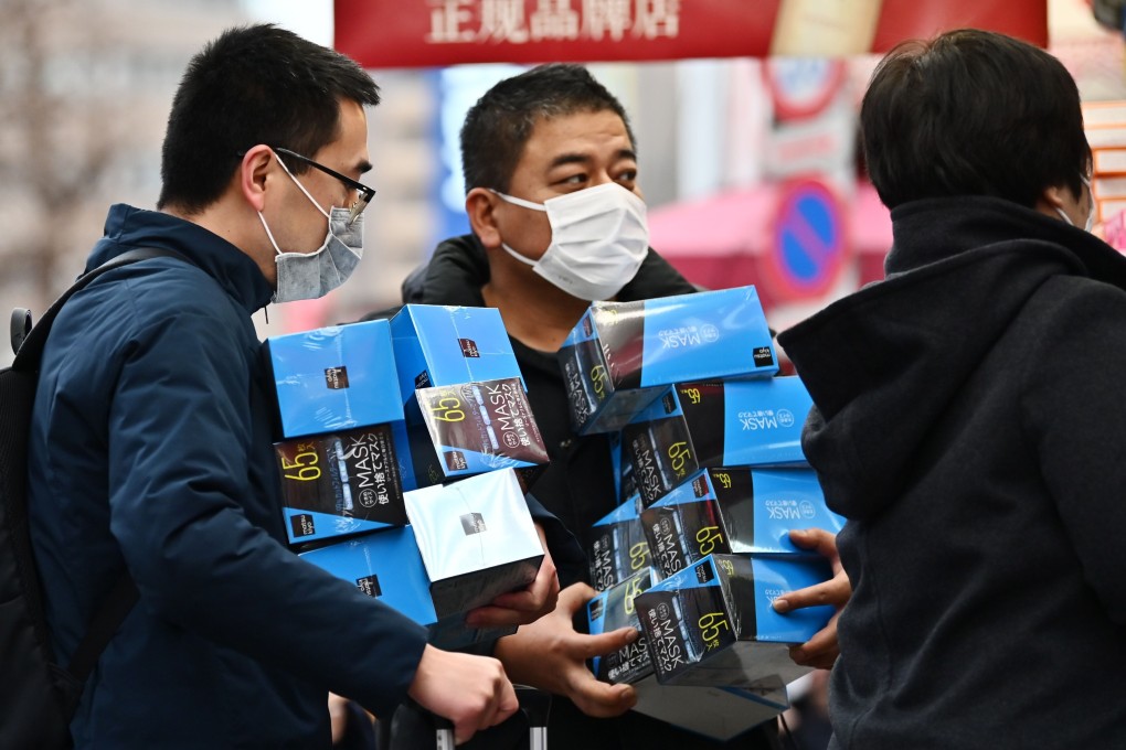 Customers buy face masks from a pharmacy in Tokyo’s Akihabara district. Photo: AFP