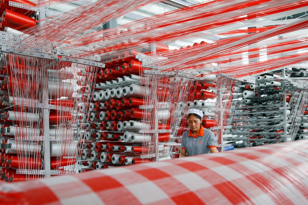 A woman works at a workshop manufacturing plastic woven materials in Suqian, Jiangsu province, China, in July 2019. Photo: Reuters