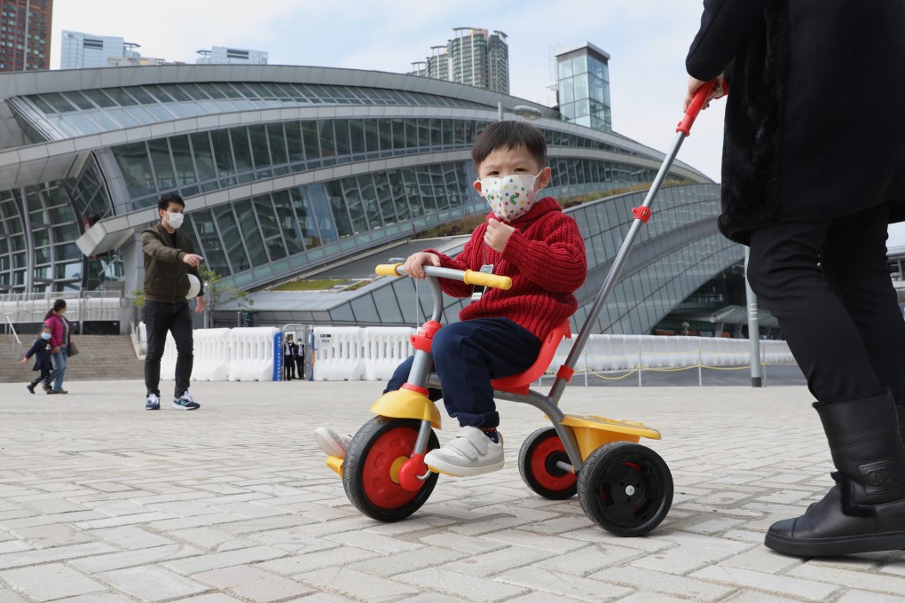 A child with a face mask plays on his bike outside the West Kowloon terminus of the high-speed railway to mainland China. Services have been suspended because of the Wuhan coronavirus outbreak. Photo: Winson Wong