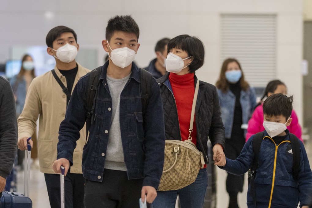 Masks on as passengers make their way through the arrival hall of the West Kowloon high-speed rail station on January 28. Hong Kong has announced the shutdown of two railway services and the suspension of new visas to individual mainland tourists. Photo: Bloomberg