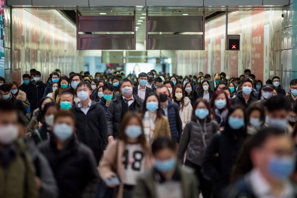 Commuters wearing protective masks walk through the MTR’s Hong Kong station. Photo: Bloomberg