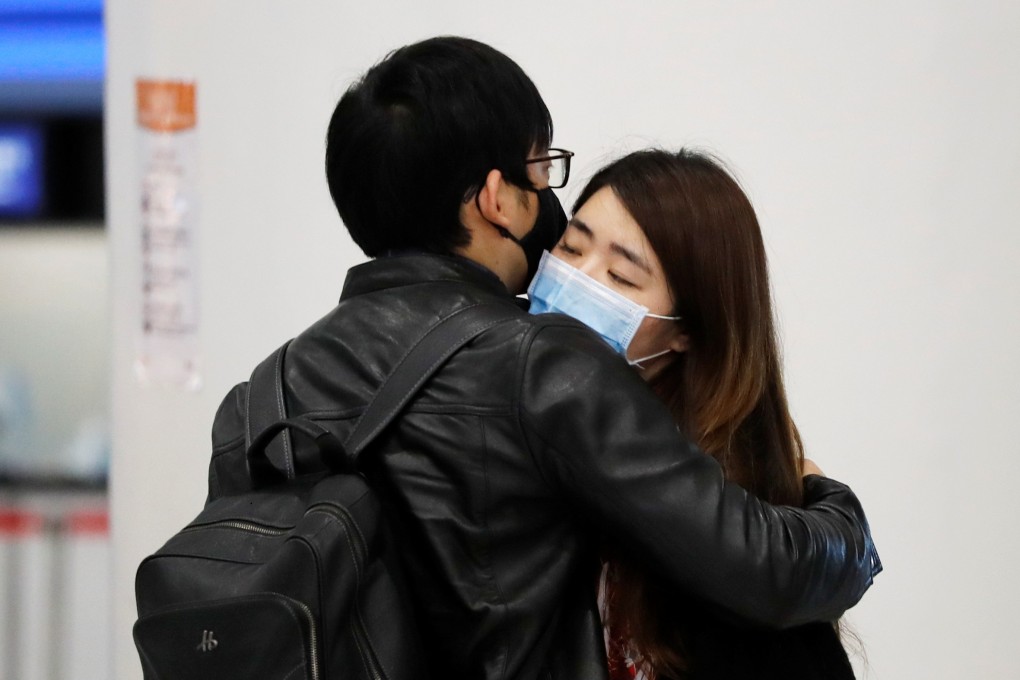 Passengers in masks as they embrace each other at Hong Kong’s high-speed rail terminus West Kowloon Station. Photo: Reuters