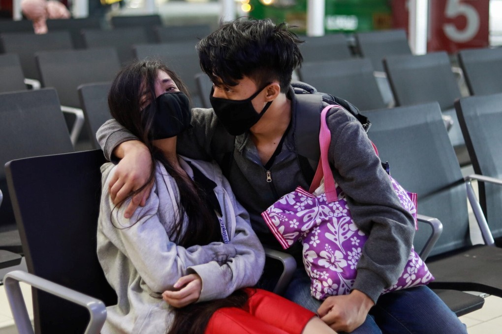 A couple wearing masks sit at a transport hub in Metro Manila on Thursday. Photo: Reuters