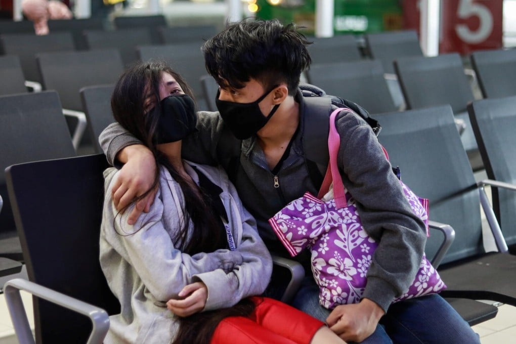A couple wearing masks sit at a transport hub in Metro Manila on Thursday. Photo: Reuters