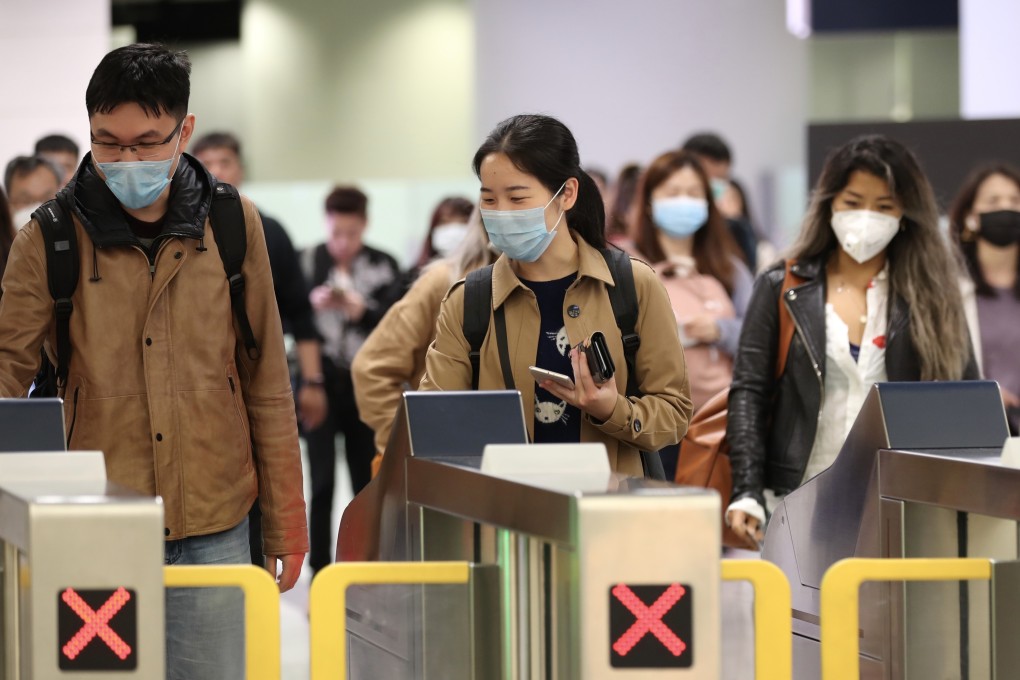 People wearing face masks pass through exit gates in the arrivals hall inside West Kowloon Station in Hong Kong. Photo: Bloomberg