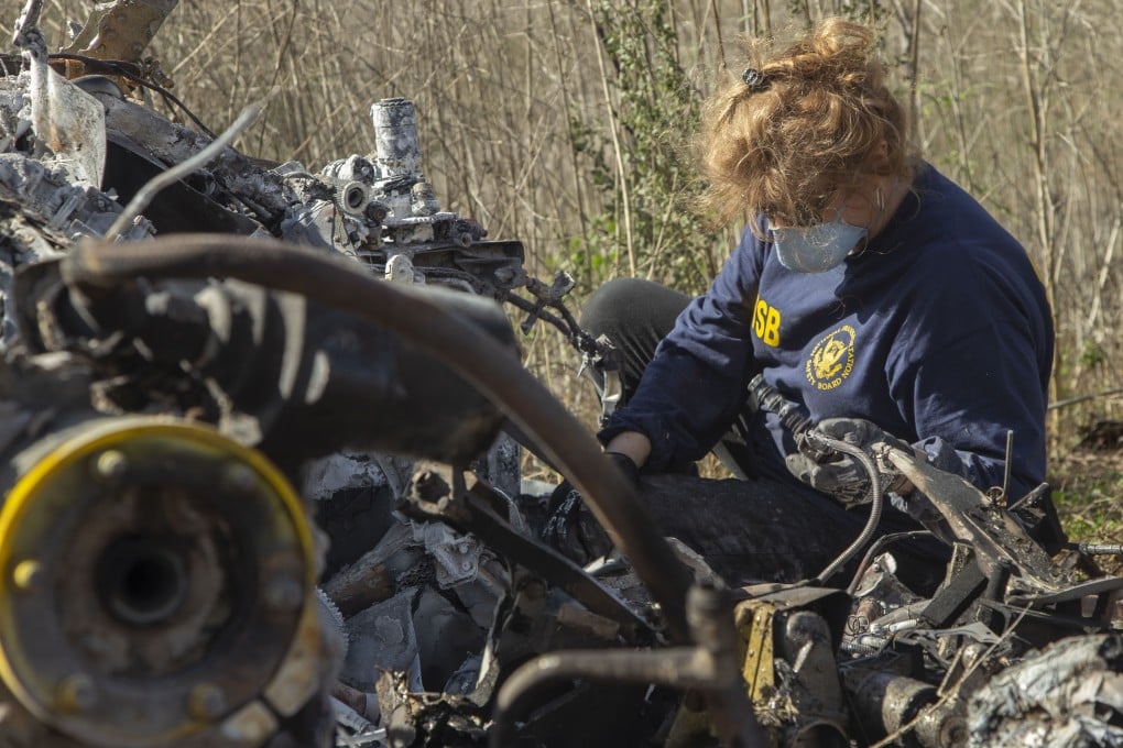 NTSB investigator Carol Hogan examines the wreckage. Photo: AP