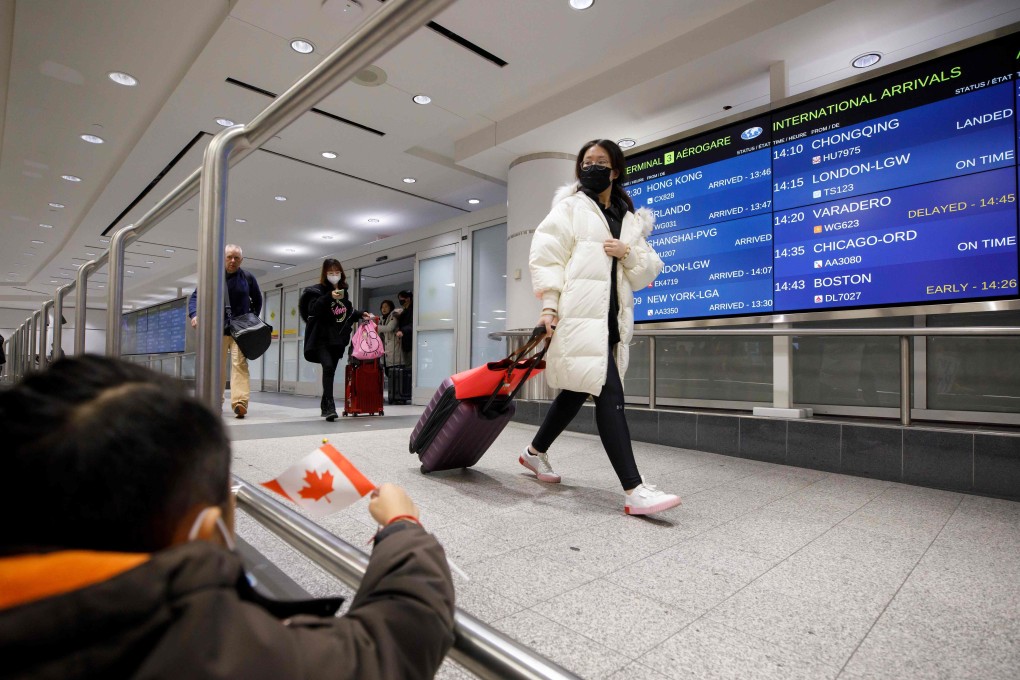 Travellers wearing masks arrive at Toronto Pearson Airport on Sunday. Photo: AFP