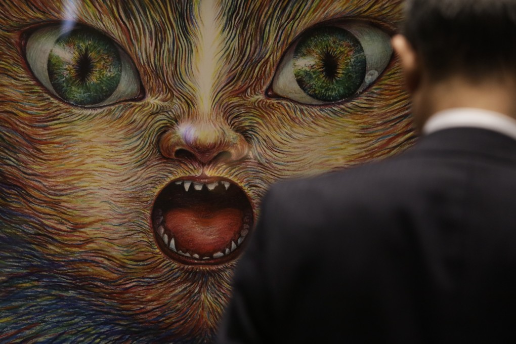 A man stands in front of a Tokyo 2020 poster created by artist Tomoko Konoike, one of 20 officially selected for the Olympics and Paralympics. Photo: AP