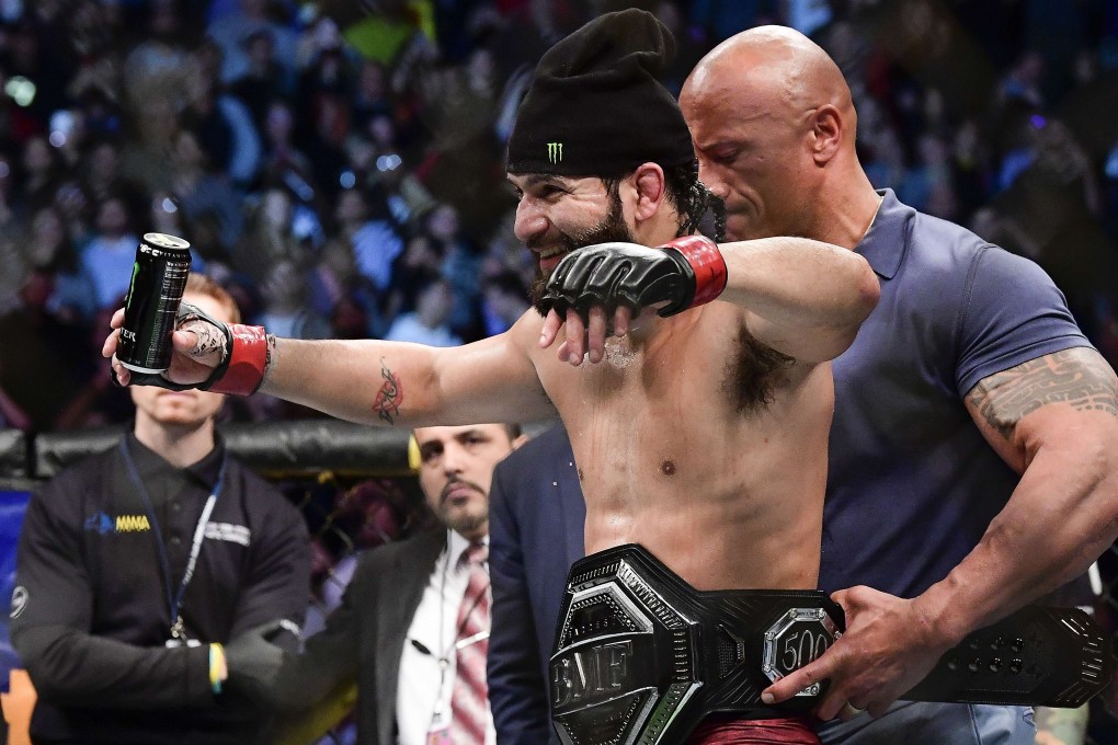 Jorge Masvidal has the BMF belt strapped around his waist by Hollywood superstar Dwayne “The Rock” Johnson after his TKO victory against Nate Diaz at UFC 244 in 2019. Photo: AFP