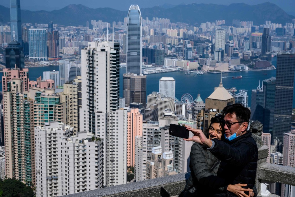 A couple take a selfie sans face masks, with Hong Kong’s famous skyline in the backdrop. Photo: AFP
