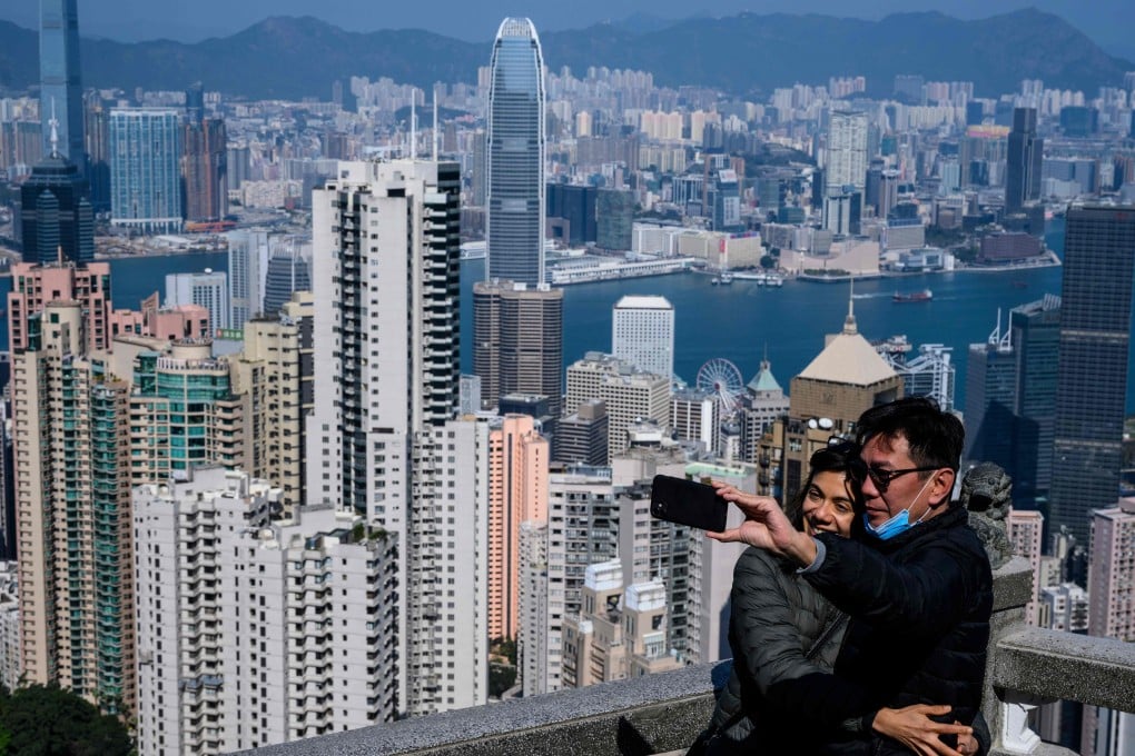 A couple take a selfie sans face masks, with Hong Kong’s famous skyline in the backdrop. Photo: AFP
