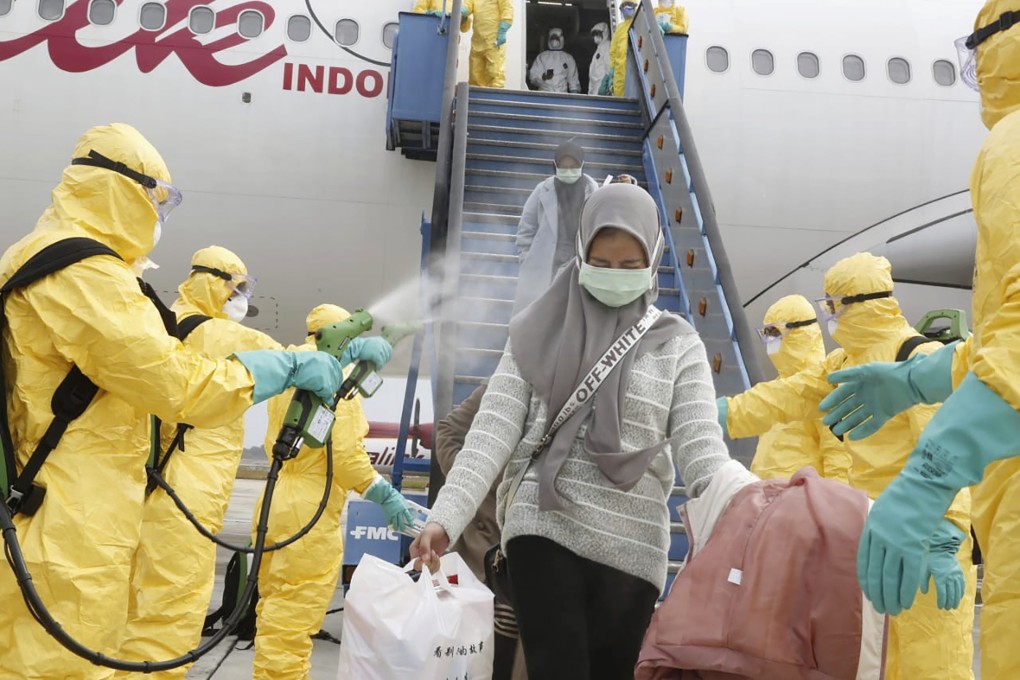 Indonesians arriving from Wuhan are sprayed with antiseptic at Hang Nadim Airport in Batam, Indonesia, on Sunday. Photo: AP