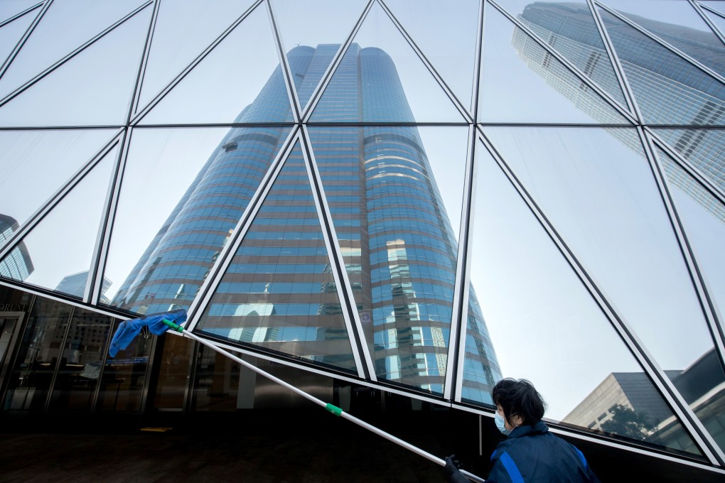 A worker wearing a protective mask cleans a window in the Central district of Hong Kong on January 31, 2020. Photo: Bloomberg
