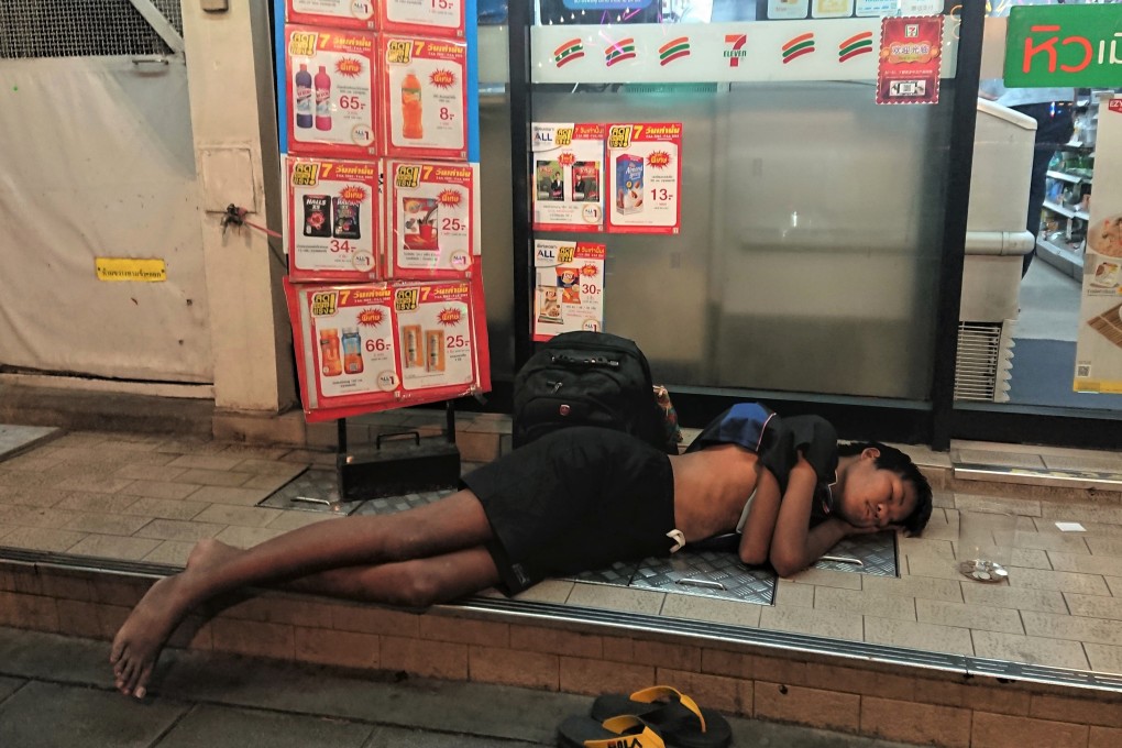 A boy, who lives on the street, sleeps outside a 7-Eleven store in central Bangkok. Many children who run away from home in Thailand end up using and selling drugs or in prostitution. Photo: Tibor Krausz
