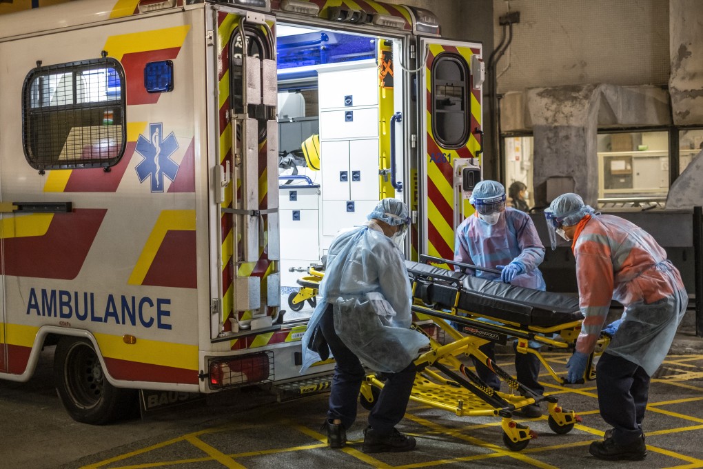 Medical officers in protective gear load a stretcher onto an ambulance outside Queen Mary Hospital in Hong Kong on January 29, 2020. Photo: Bloomberg