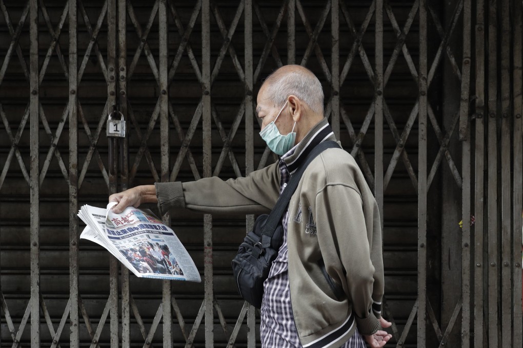 A man wearing a protective mask in Manila’s Chinatown reads a Chinese-language newspaper that says “Philippines bans travellers from China, Hong Kong and Macau”. Photo: AP