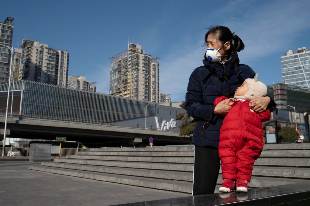 A mother wearing a protective face mask in Beijing. The new coronavirus has already infected more people in China than Sars did in 2003. Photo: Reuters