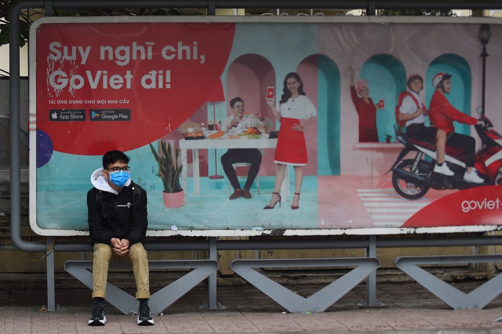 A man wearing a protective facemask sits at a bus stop in Hanoi amid rising concerns over the novel coronavirus outbreak. Photo: AFP