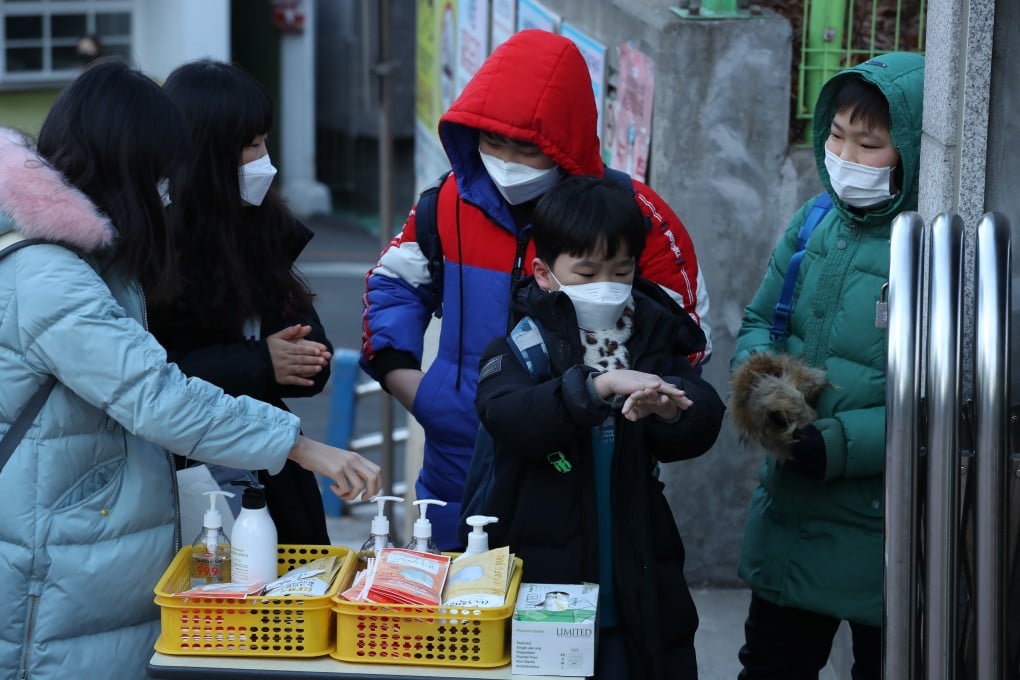 A student sanitises his hands outside Nambu Elementary School in Seoul, South Korea. Photo: EPA