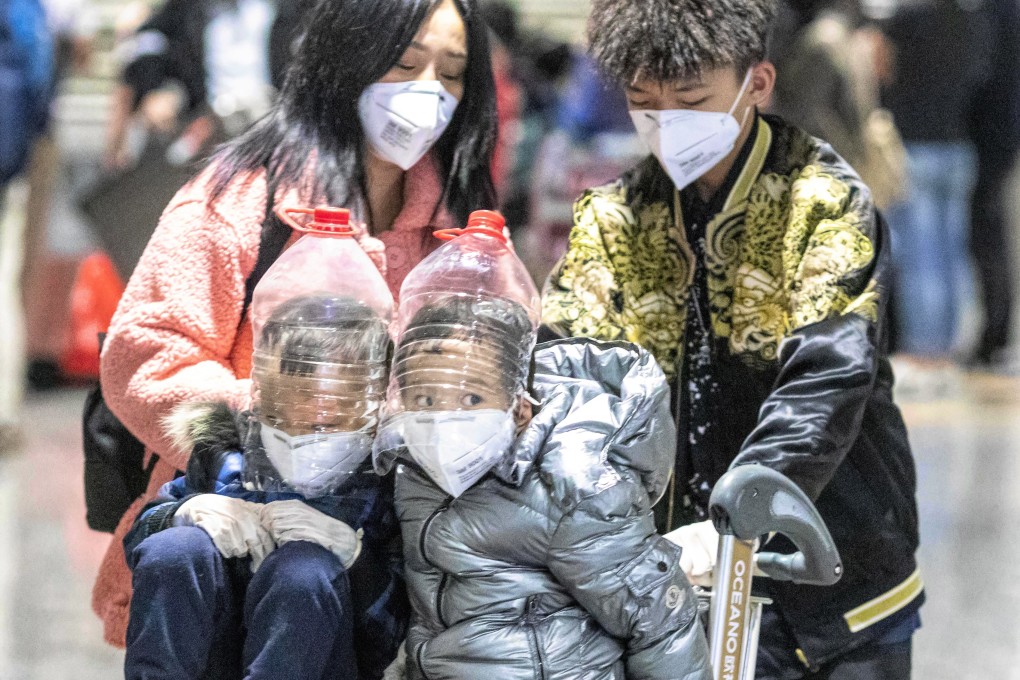 Children wear face protection improvised from water bottles at Guangzhou airport’s arrival terminal on February 1. Photo: EPA-EFE