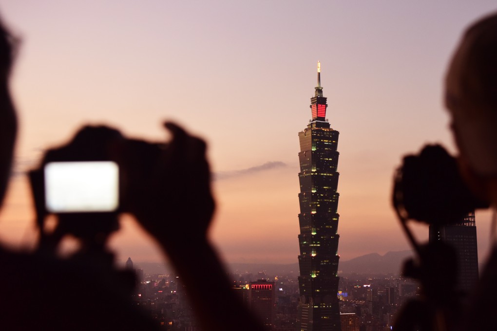Tourists take photos of the Taipei 101 skyscraper. Visitors from Hong Kong and Macau are the fourth biggest spenders in Taiwan after Japanese, mainland Chinese and South Koreans. Photo: Xinhua