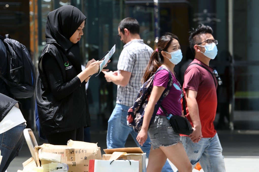 A volunteer from Singapore's Ministry of Communication collects feedback from members of the public on the coronavirus situation. Photo: AFP