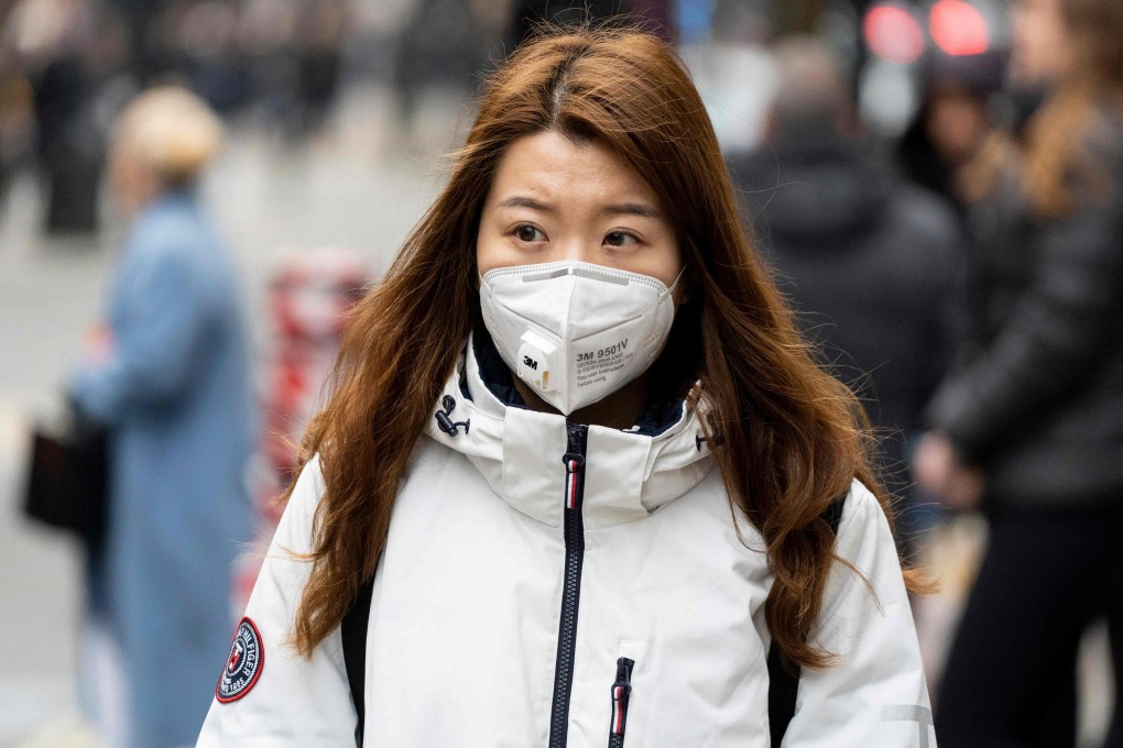 A pedestrian wears a surgical mask while walking along London’s Oxford Street. Photo: AFP