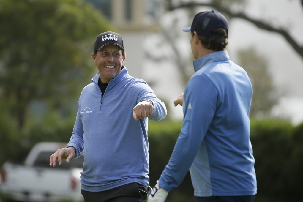 Phil Mickelson greets Steve Young after chipping the ball in on the 14th hole of the Pebble Beach Golf Links. Photo: AP