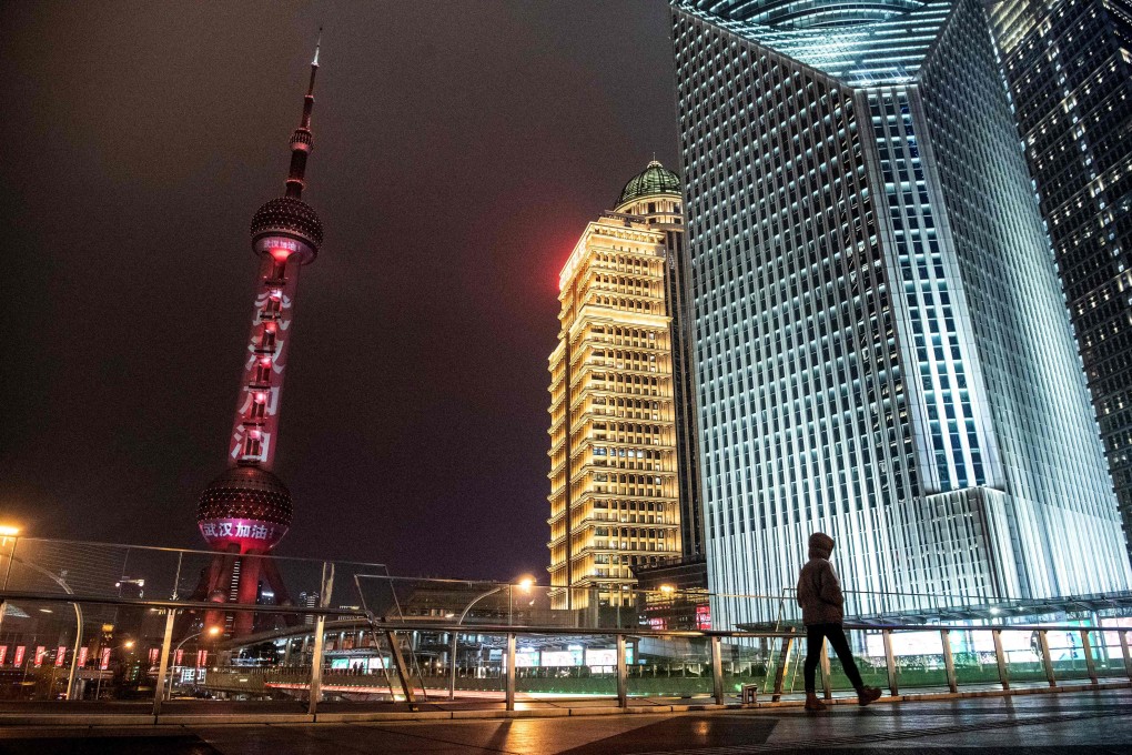 A man walks in front of the Oriental Pearl Tower in Shanghai, which is projecting the message: “Wuhan, keep going”. China’s efforts to contain the spread of the new coronavirus first detected in Wuhan are giving a shock to the country’s economy. Photo: AFP