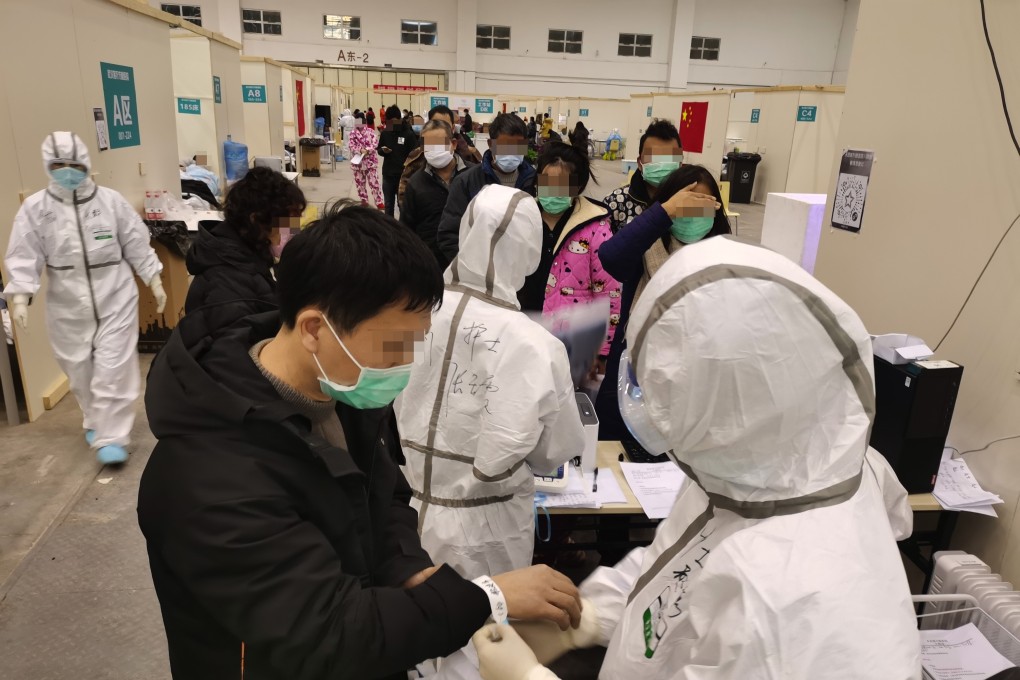 Medical workers take in patients at a cultural building converted into a treatment centre for coronavirus cases in Wuhan. Photo: Xinhua