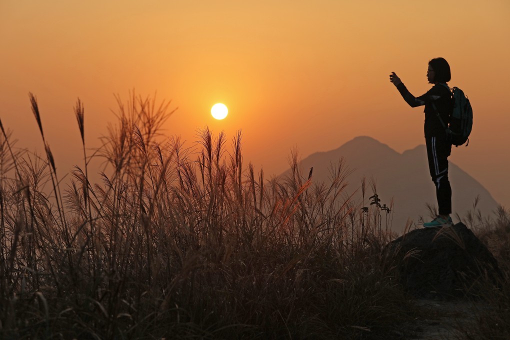 A hiker enjoys the view at Sunset Peak, Hong Kong. Exercising outdoors helps to reduce anxiety and depression. Photo: Felix Wong