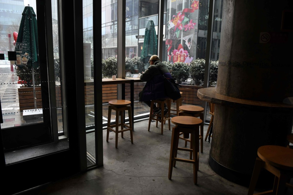 A lone customer sits in an empty cafe in Beijing on February 5, as China fights to contain the coronavirus outbreak. Photo: AFP