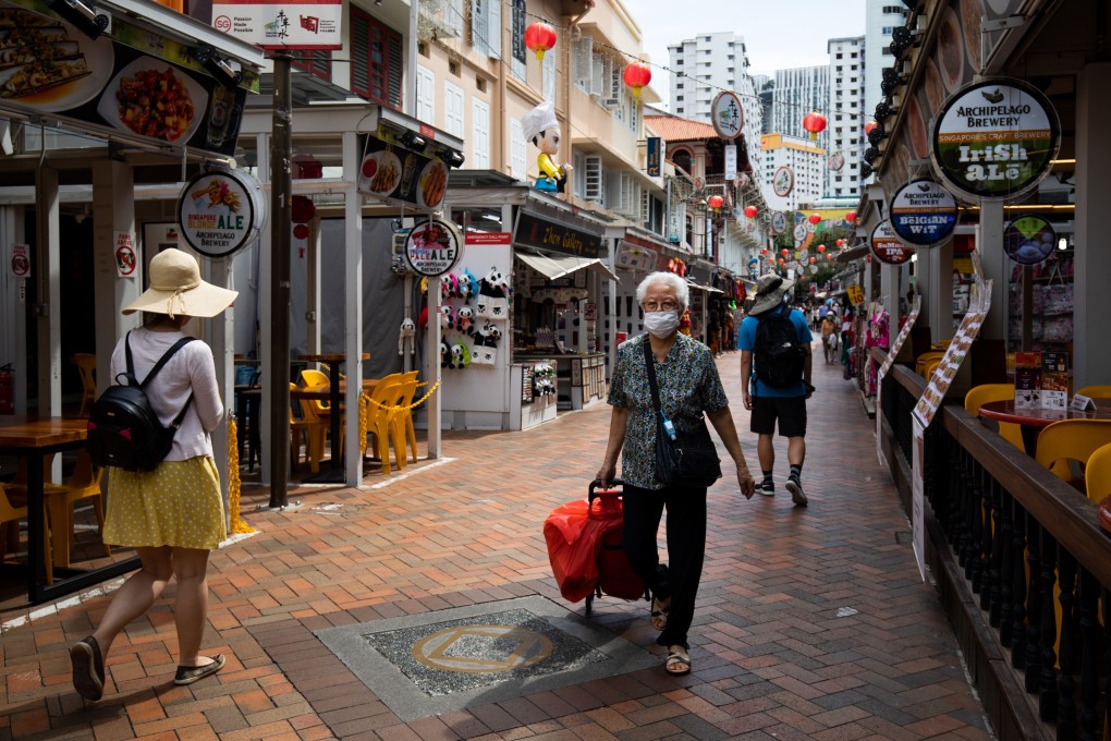 A shopper wearing a protective mask walks past stores in the Chinatown area of Singapore on February 10. Singapore has raised its disease response level to the same grade used during the Sars epidemic. Photo: Bloomberg