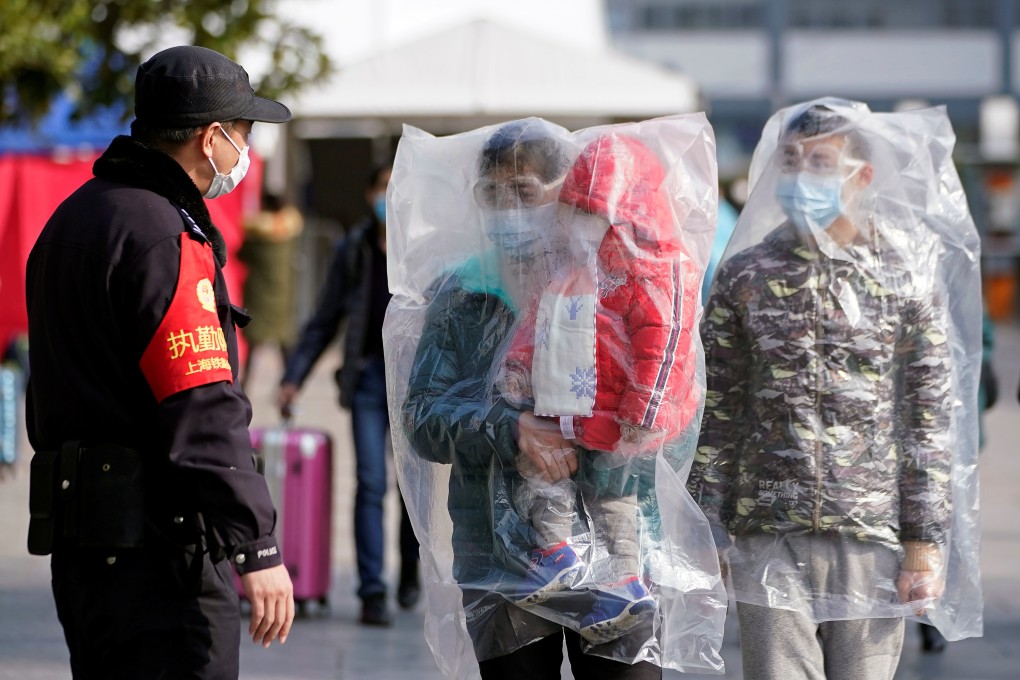Passengers wearing masks and covered with plastic bags walk outside the Shanghai railway station in Shanghai, China, as the country is hit by an outbreak of a new coronavirus, February 9, 2020. Photo: Reuters