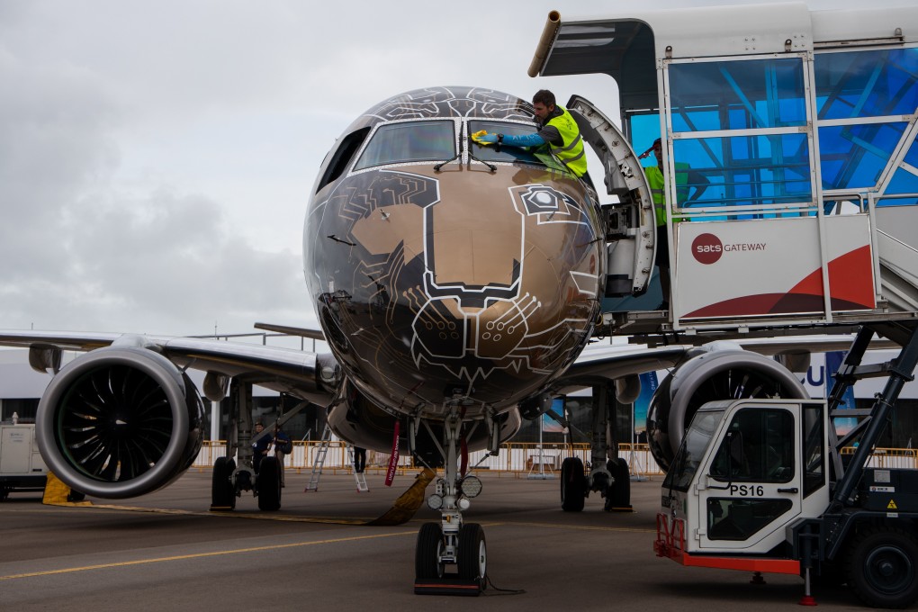 A worker wipes the window glass of cockpit of an Embraer SA 195-E2 aircraft on display at the Changi Exhibition Centre in Singapore. Photo: Bloomberg