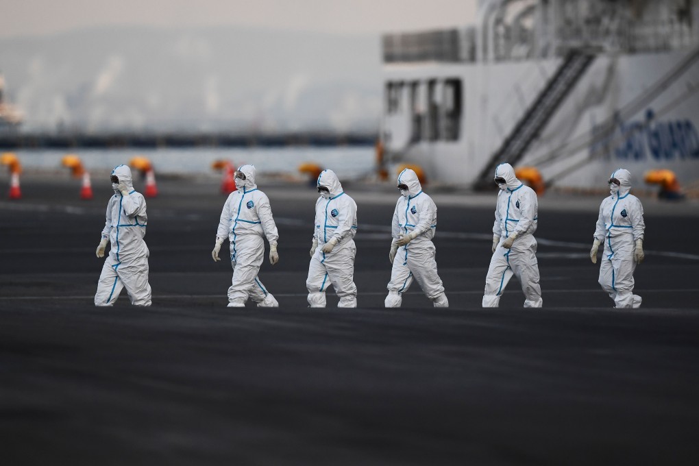 People wearing protective suits walk from the Diamond Princess cruise ship, aboard which around 3,600 people are quarantined due to fears of the new coronavirus, in Yokohama port. Photo: AFP