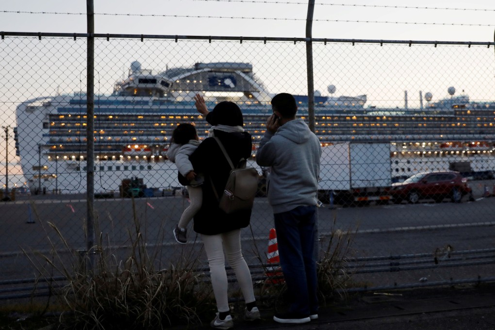 Family members of passengers on board the cruise ship Diamond Princess wave and talk to them on the phone at Daikoku Pier Cruise Terminal in Yokohama, Japan. Photo: Reuters