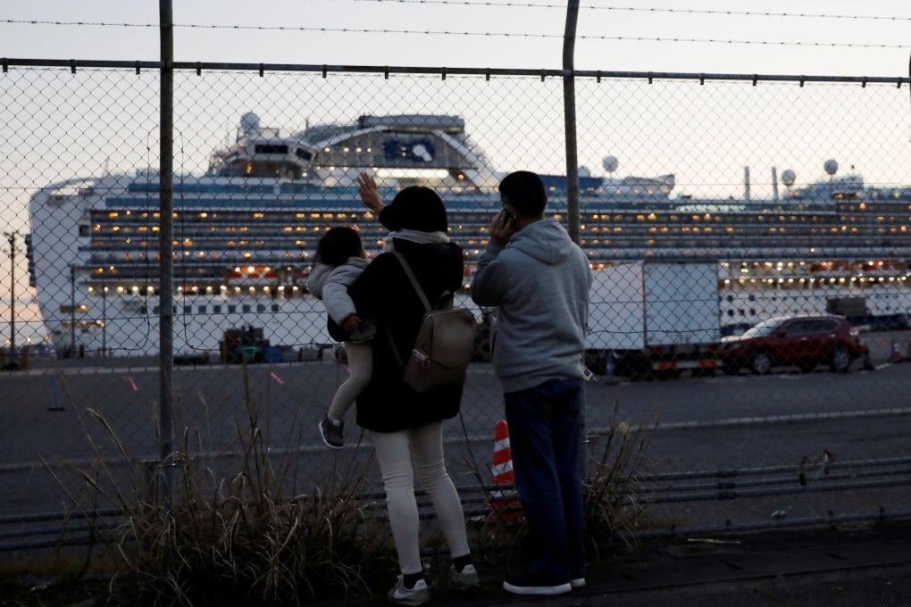 Family members of passengers on board the cruise ship Diamond Princess wave and talk to them on the phone at Daikoku Pier Cruise Terminal in Yokohama, Japan. Photo: Reuters