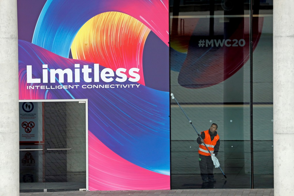 An operator cleans up a window at the entrance of the Fira Gran Via, venue for the MWC Barcelona trade show. Photo: EPA-EFE