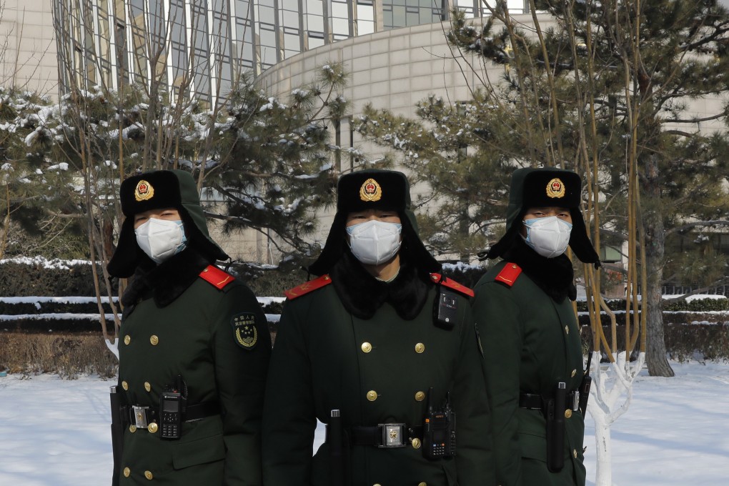 Chinese paramilitary police officers wearing face masks stand outside the headquarters of the People’s Bank of China in Beijing. Photo: EPA-EFE