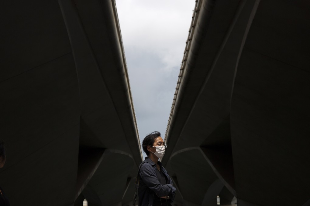 A man wearing a protective face mask walks under a bridge near Merlion Park in Singapore on February 12. The Monetary Authority of Singapore has signalled there is room for further easing in response to weaker growth prospects due to the coronavirus. Photo: EPA-EFE