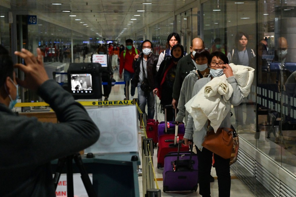 Travellers walk past a thermal camera upon arrival at Manila’s international airport earlier this month. Photo: AFP