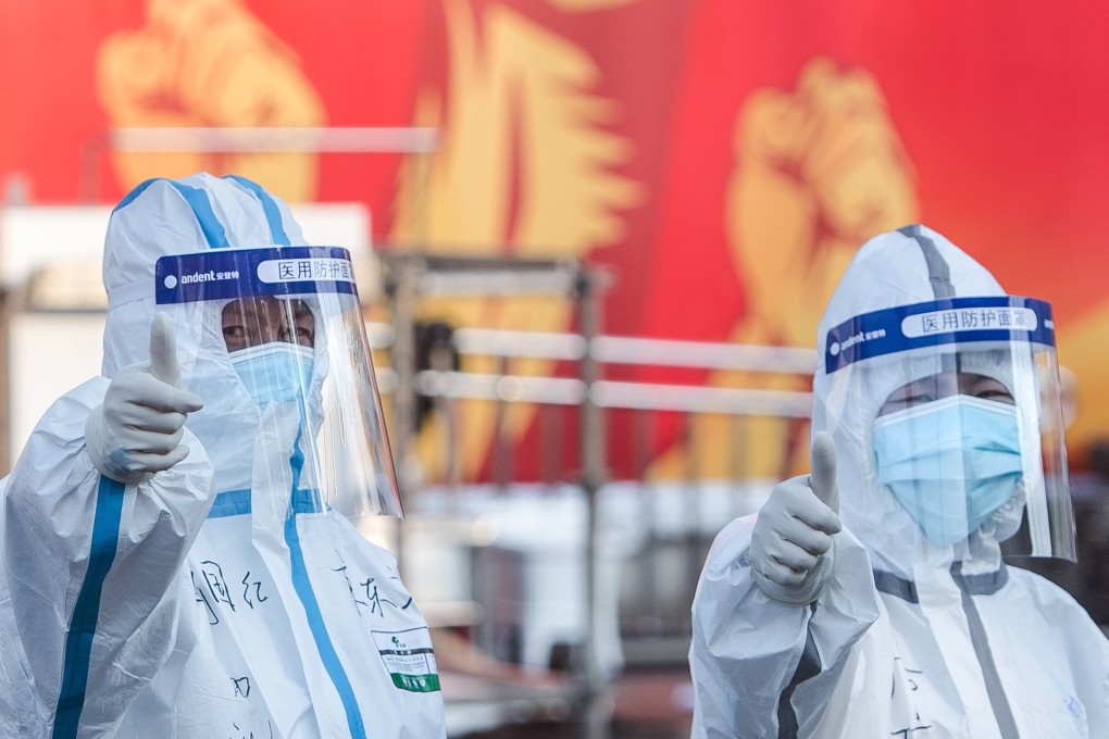 Thumbs up from health workers in Wuhan, where 11 million people, including 15,000 foreigners, live under lockdown. Photo: Xinhua