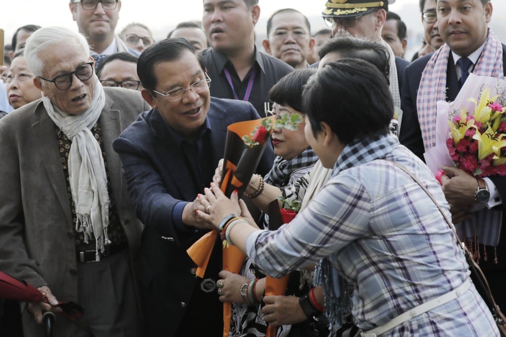 Cambodian Prime Minister Hun Sen greets passengers as they disembark. Photo: EPA